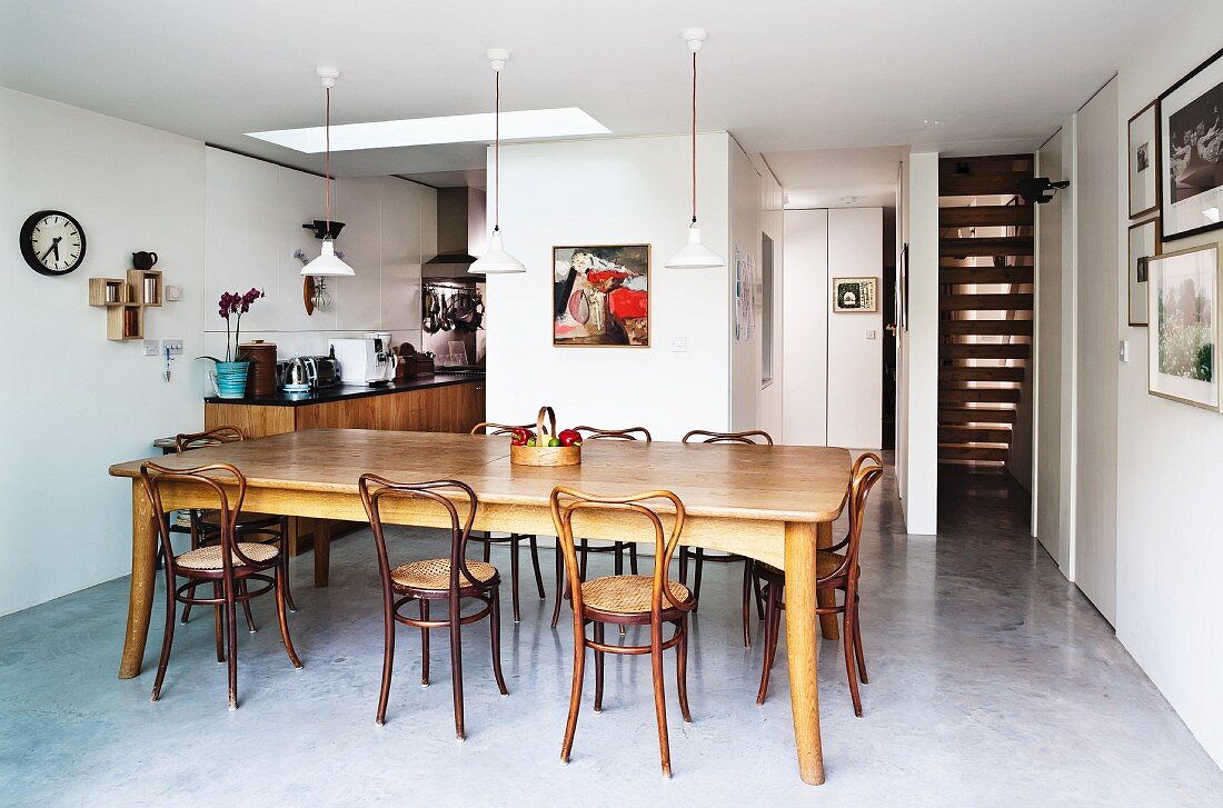 Dining room with concrete floor, long dining room and wooden chairs with curved backs