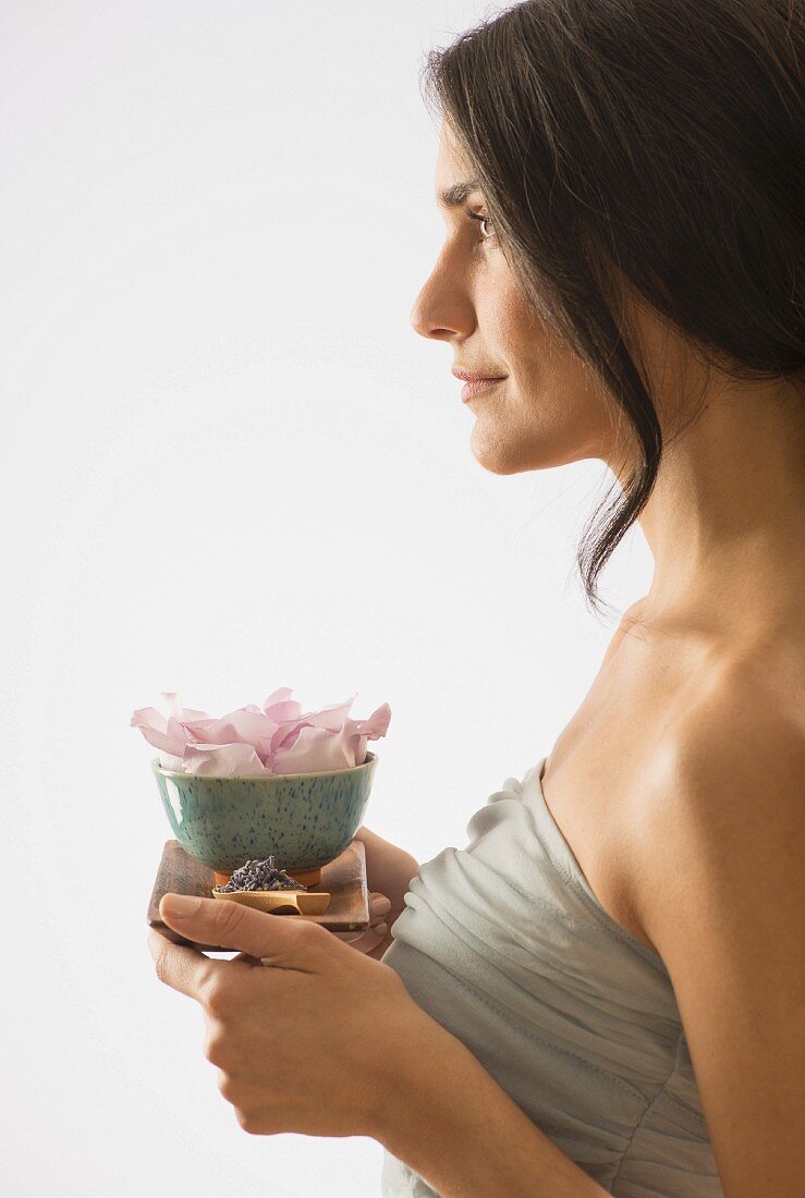 Frau hält Tablett mit duftenden Blüten