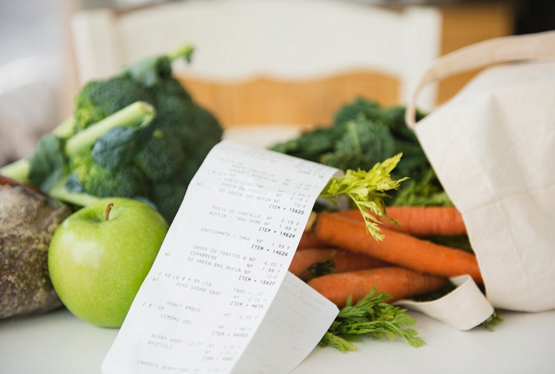 Apfel und Gemüse mit Einkaufstasche und Rechnung