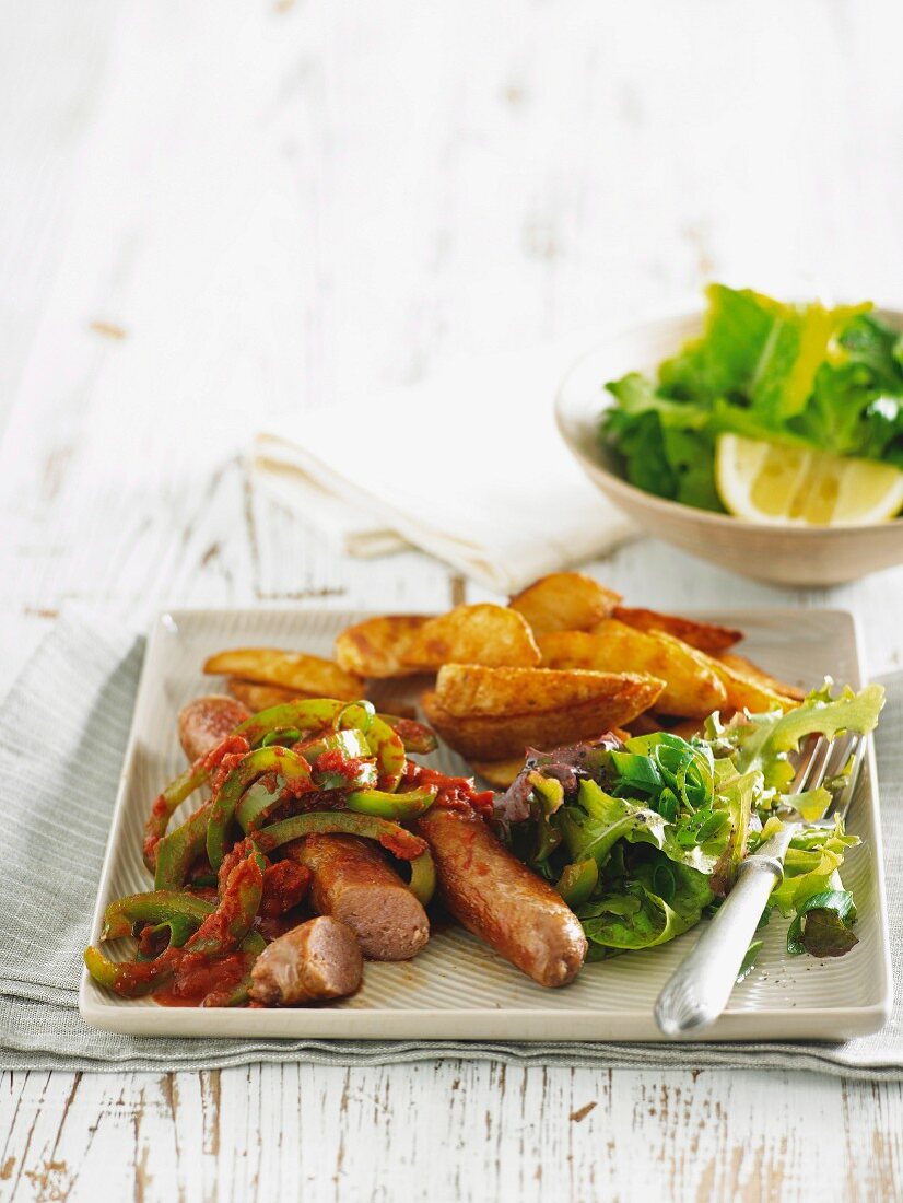 Sausages with braised peppers and potato wedges