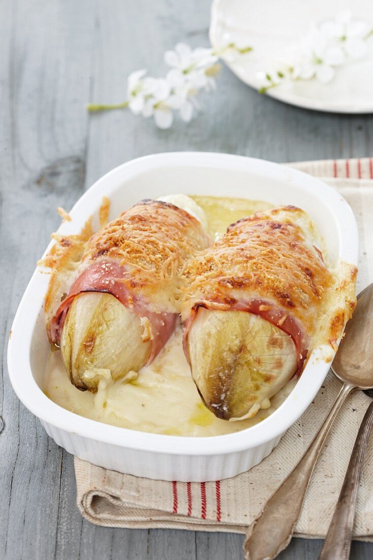 Gratinated chicory wrapped with ham