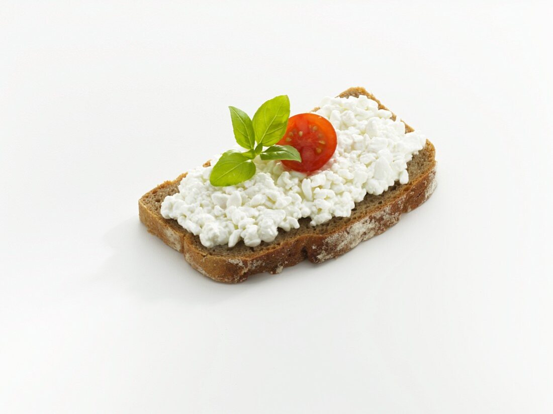 Bread topped with cottage cheese, tomato and basil