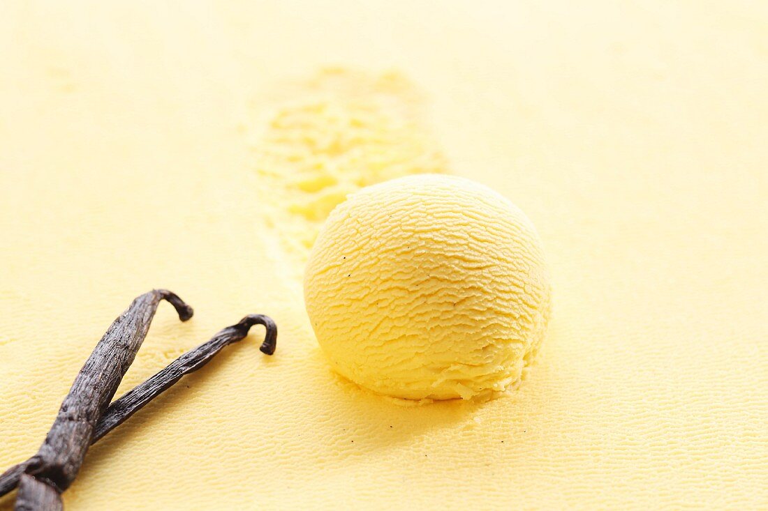 A scoop of vanilla ice cream with vanilla pods