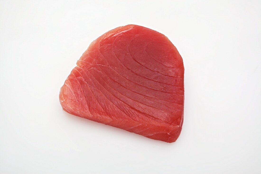 Raw tuna steak on a white surface