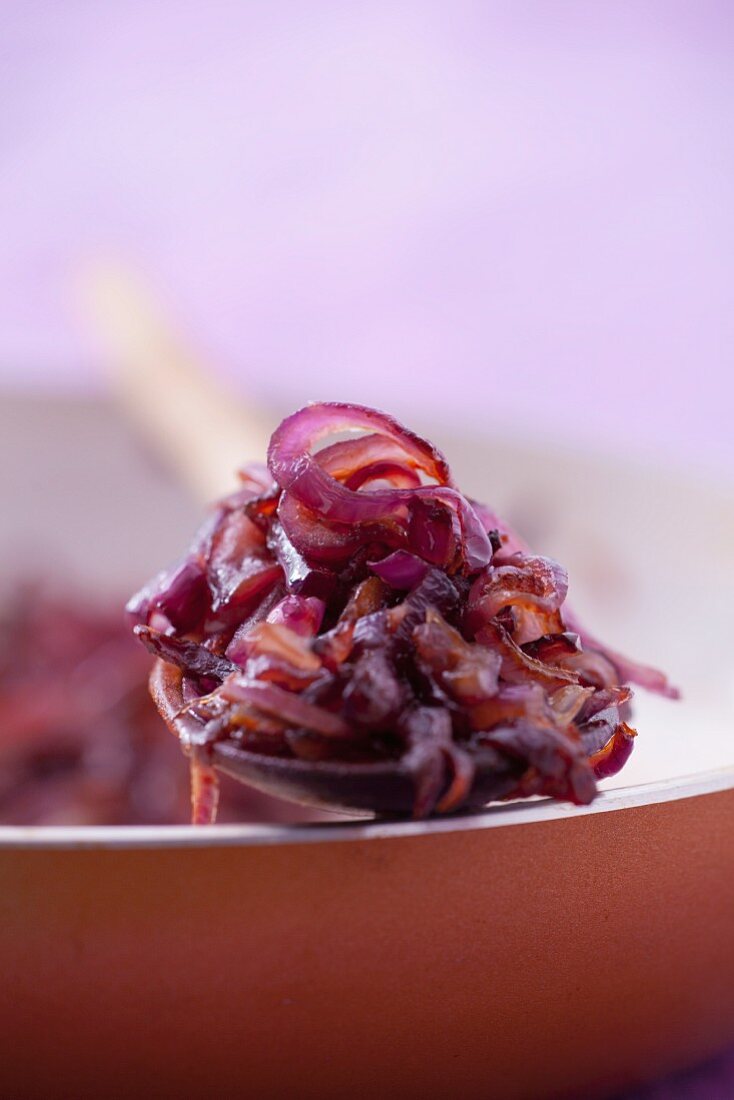 Fried red onions on a wooden spoon