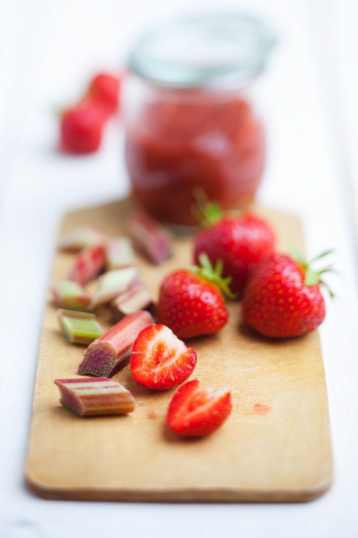 Strawberries, rhubarb and strawberry & rhubarb jam on a wooden board