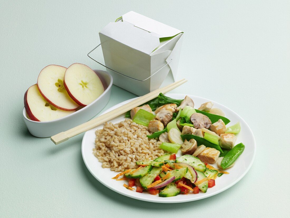 Chinese Take Out Dinner on a Plate with Take Out Carton, Apples and Chopsticks