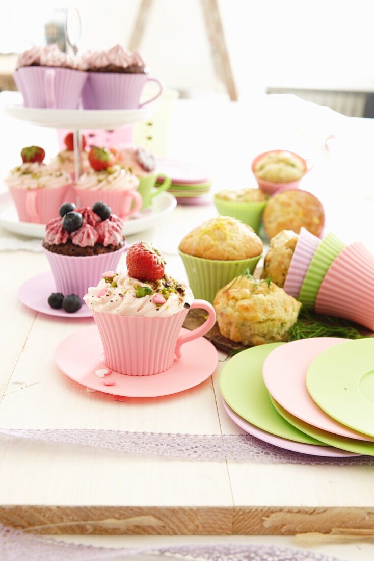 Verschiedene Cupcakes und Muffins in pastellfarbenen Förmchen