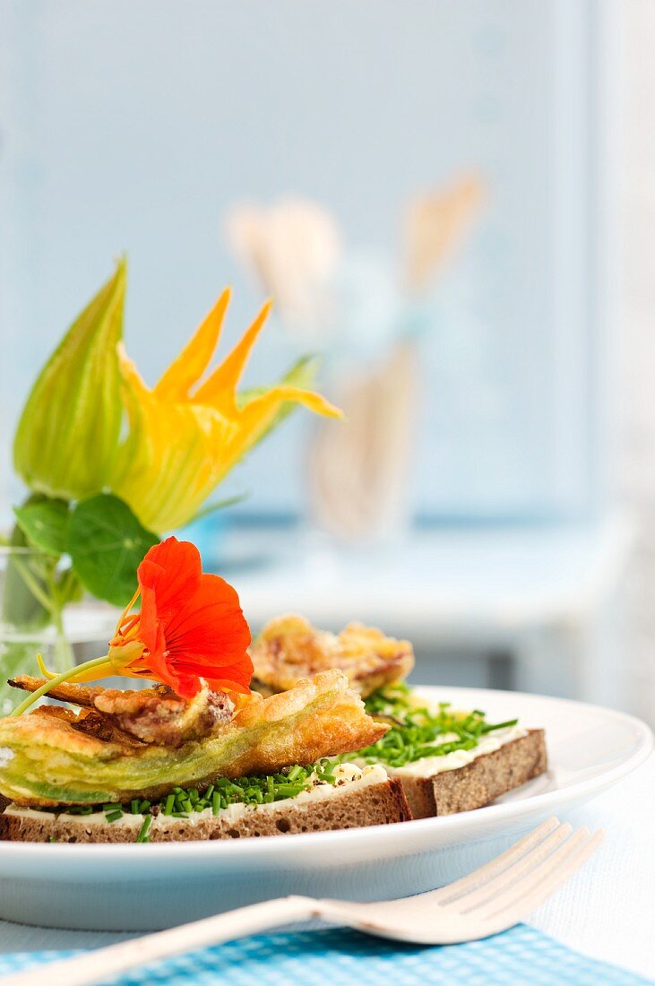 Bauernbrot mit Schnittlauch, frittierten Zucchiniblüten und Kapuzinerkresse