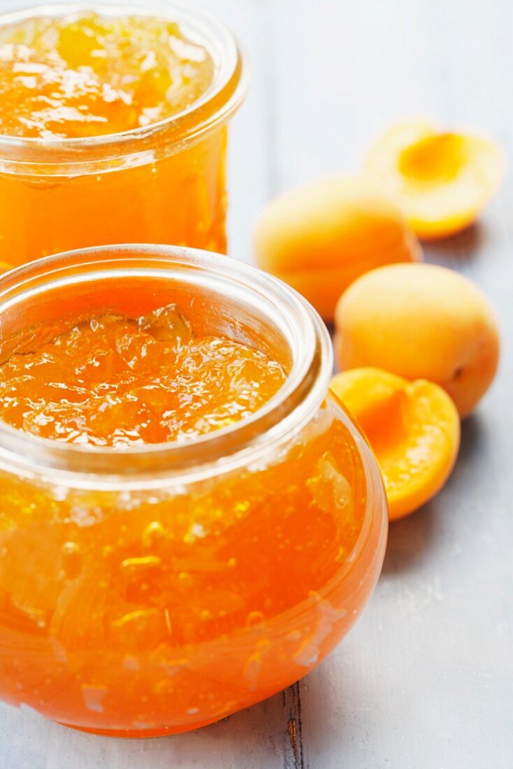 Apricot jam in jars on a wooden surface