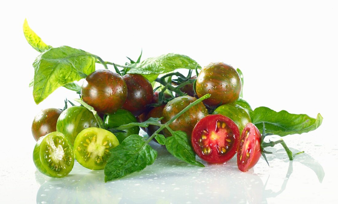 Grüne und rote Kirschtomaten mit Wassertropfen