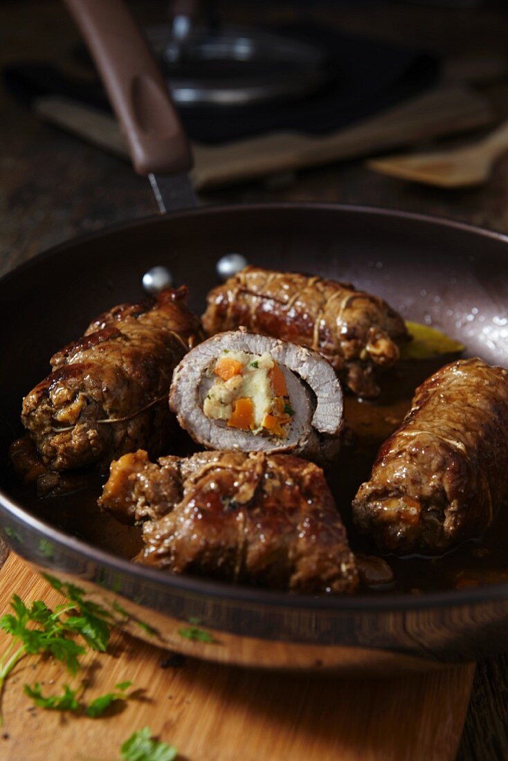 Stuffed rolled veal parcels in a frying pan