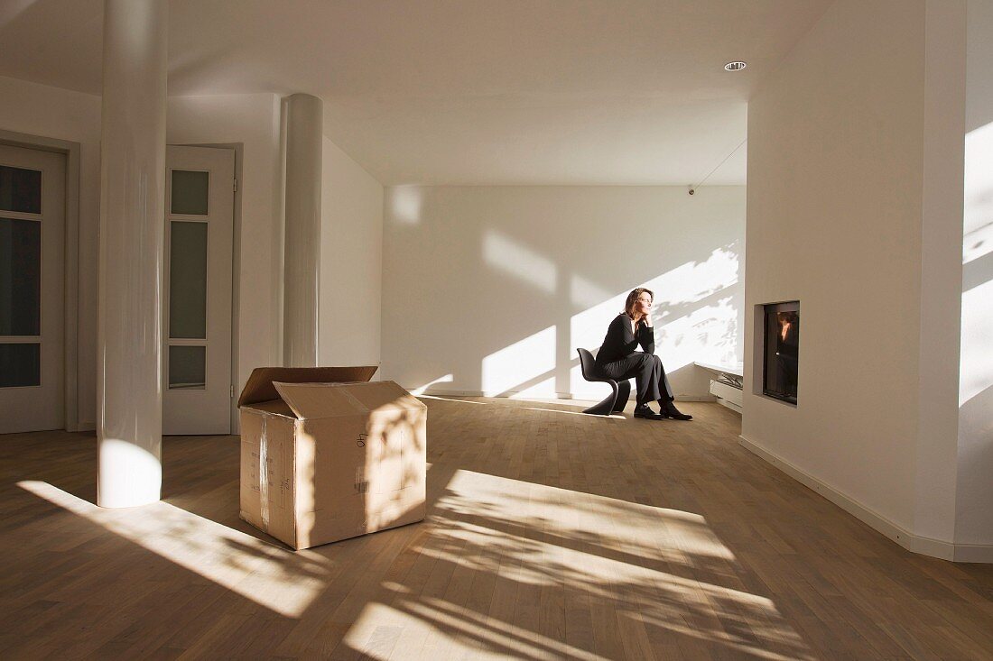 Woman sitting on chair in empty room