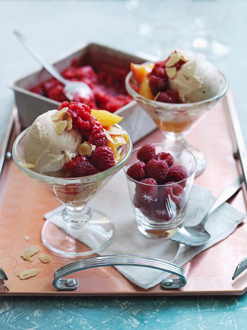 Nellie Melba – an ice cream sundae made with almond ice cream, fresh raspberries and peaches – with a tub of raspberry granita in the background