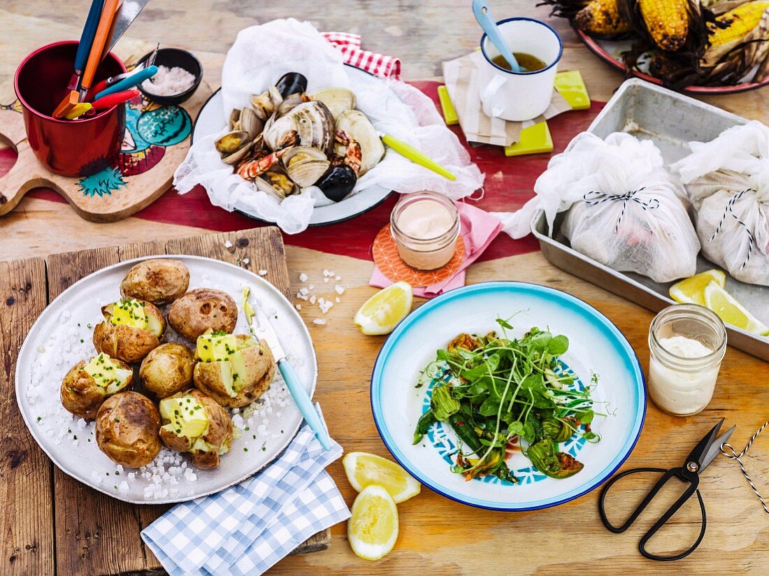 A buffet featuring mussels, new potatoes and steamed courgette flowers