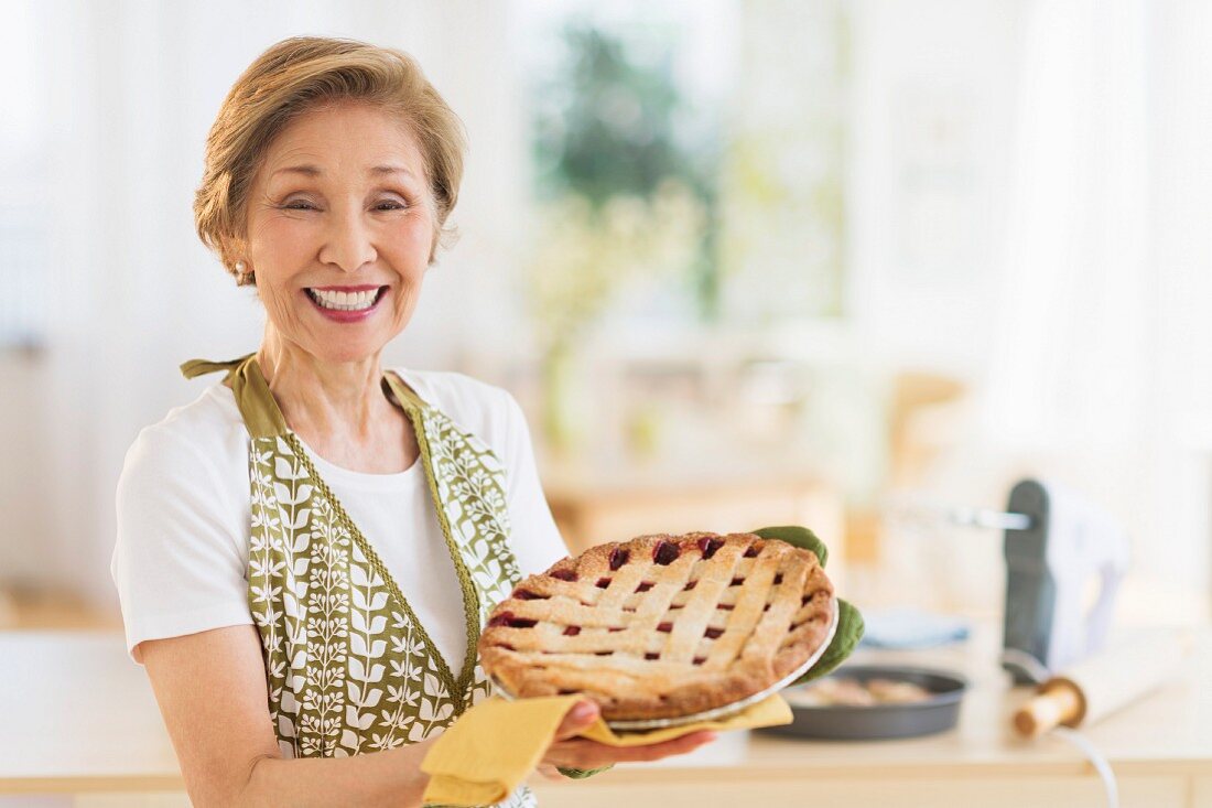 A woman proudly holding up a home-made pie