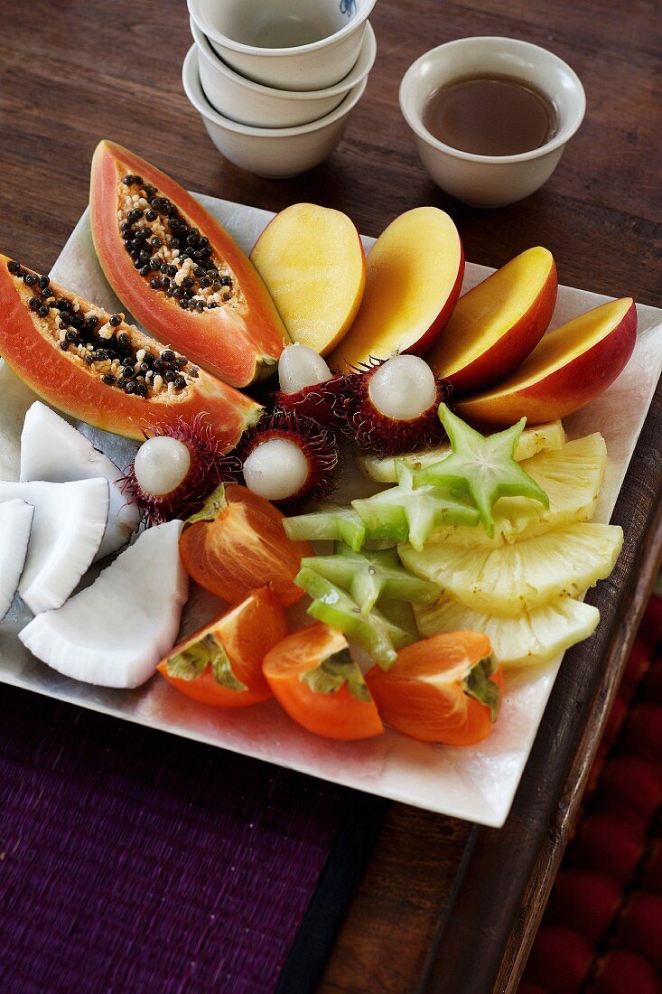 A dessert platter with fresh exotic fruits and lime syrup