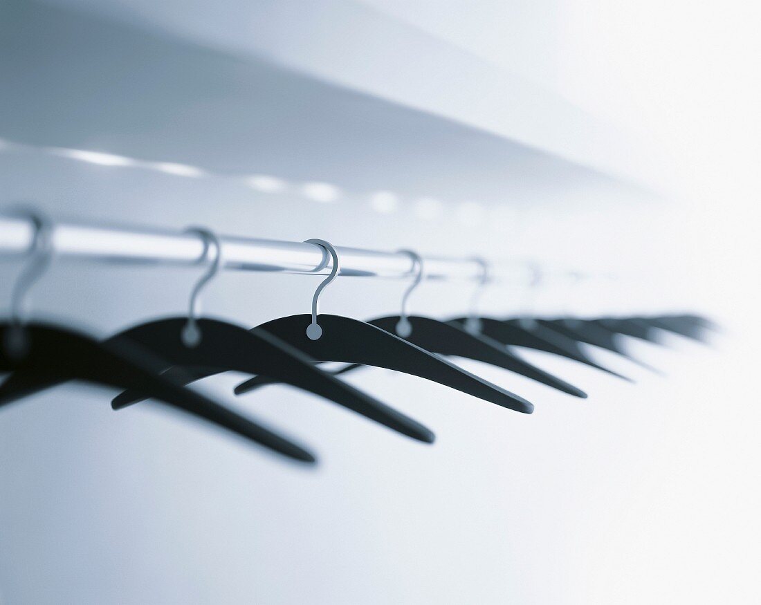 Coat hangers hanging from clothes rack