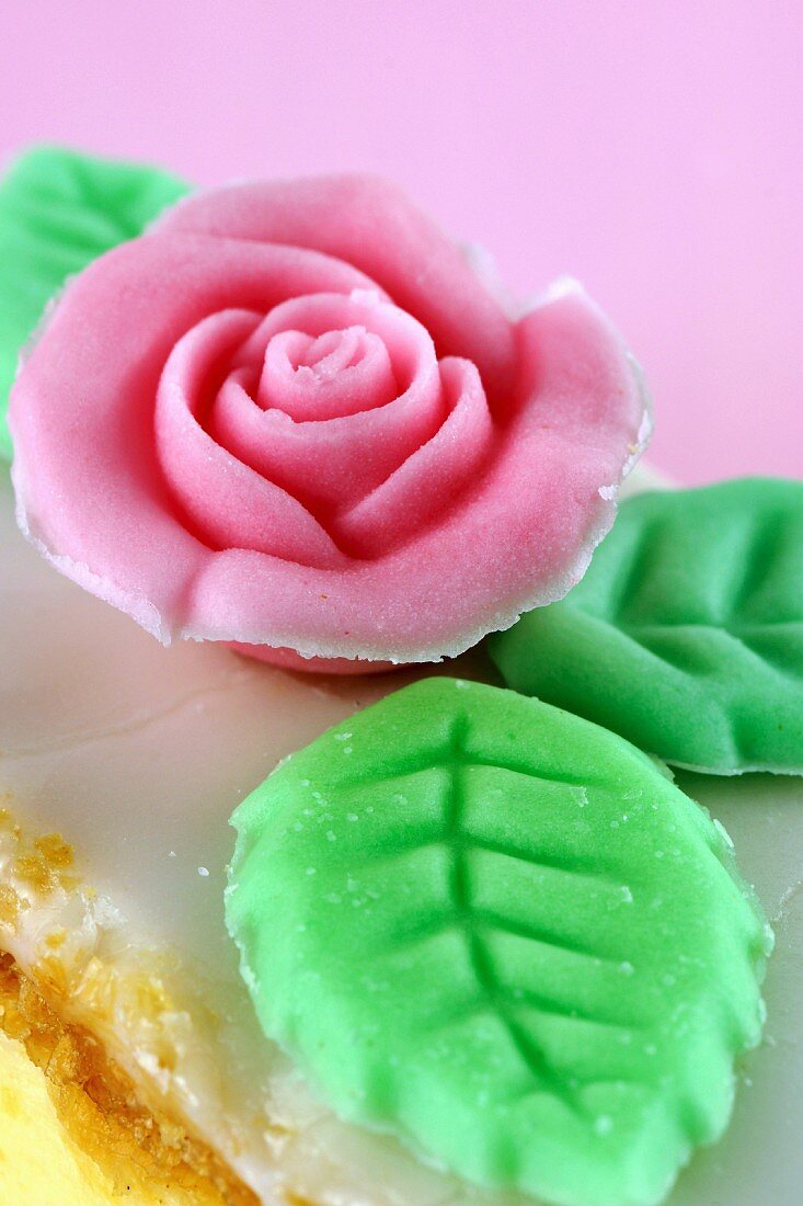 Sugar rose with leaves as decoration on a slice of cake