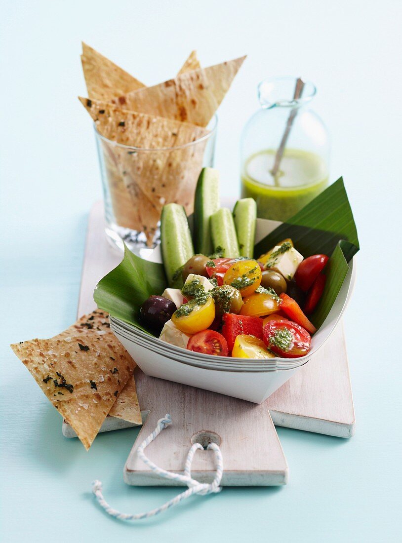 Griechischer Salat in Pappschälchen, dazu Lavash Crisps