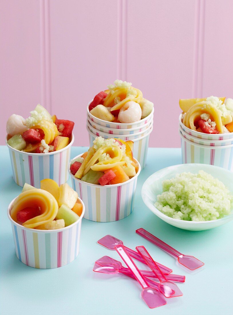 Honeydew melon granita with exotic fruit salad in paper ice cream tubs