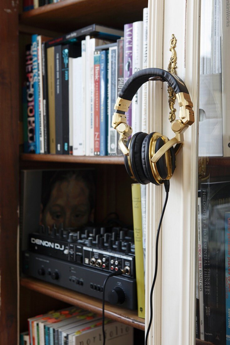 Vitrinenschrank für Bücher und Musikanlage; Kopfhörer an Schrankschlüssel aufgehängt