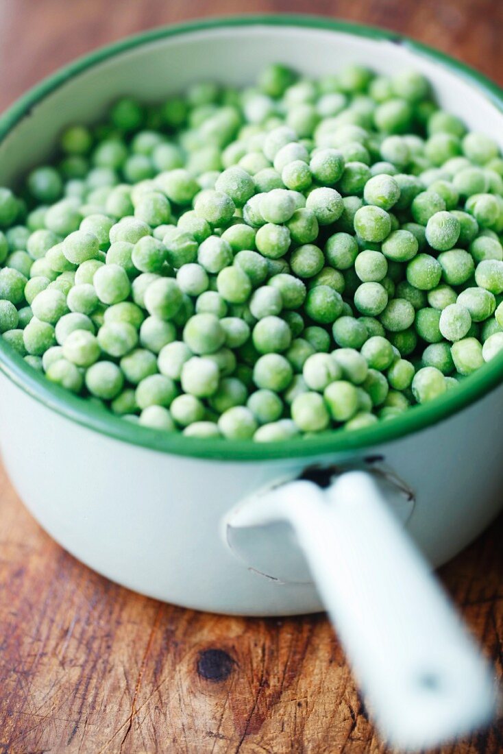 Frozen peas in a green saucepan