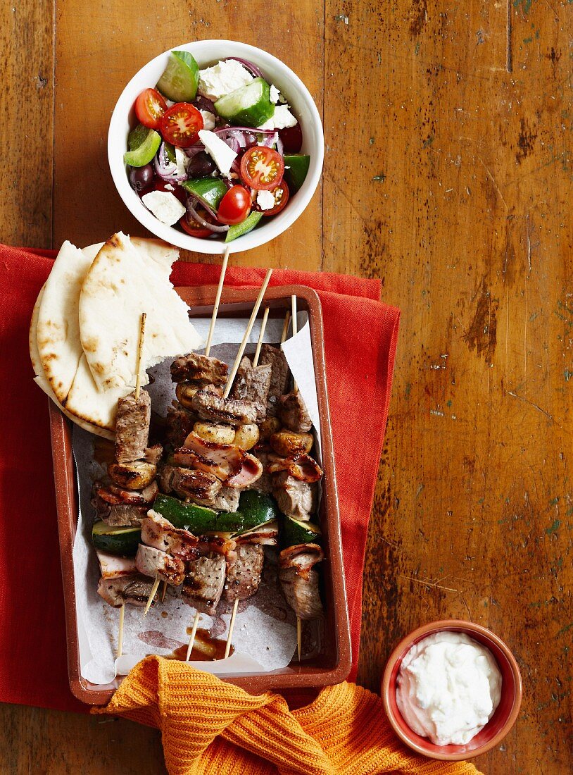 Beef skewers with bacon and courgette, served with a Greek salad