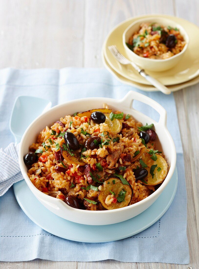 Paella mit Hähnchen, Salami, Oliven und Zitronen