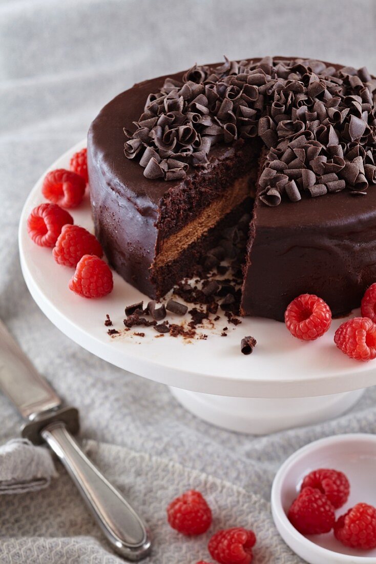 Schokoladen-Kuchen mit Schokolade Ganache Curls und Himbeeren; angeschnitten