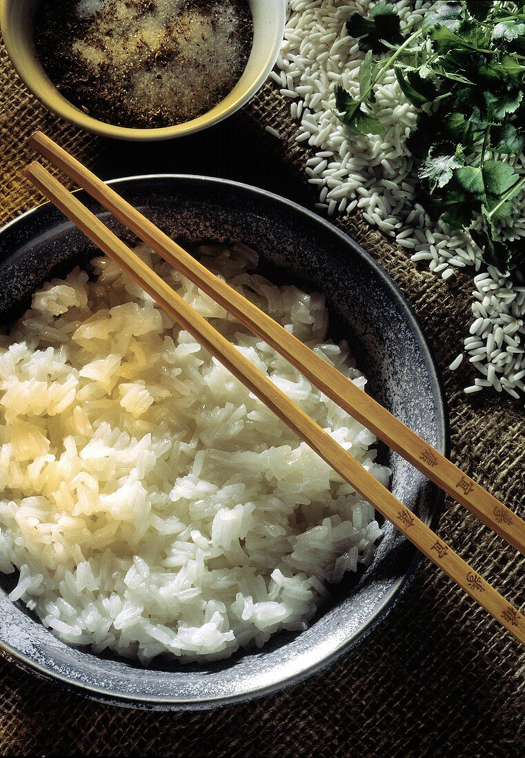 Ein Schälchen Reis auf chinesische Art gekocht, Stäbchen u.a.