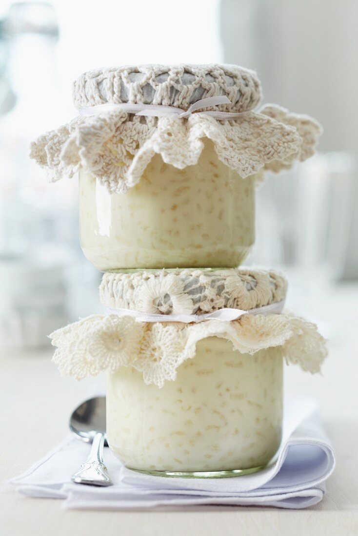 Jars of rice pudding topped with crocheted doilies for presents