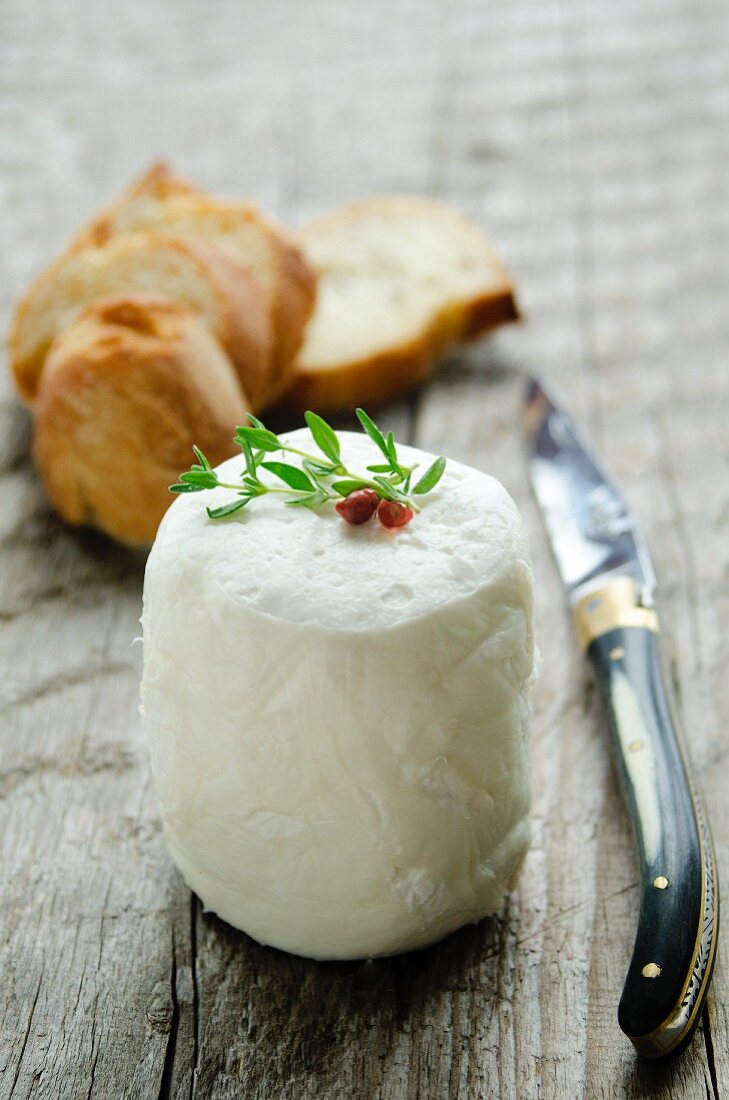 Goat's cheese with a knife and slices of baguette