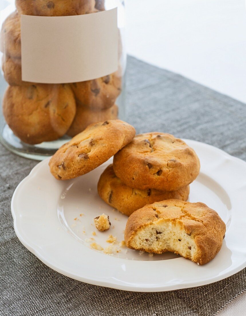 Chocolate chip cookies on a plate and in a storage jar