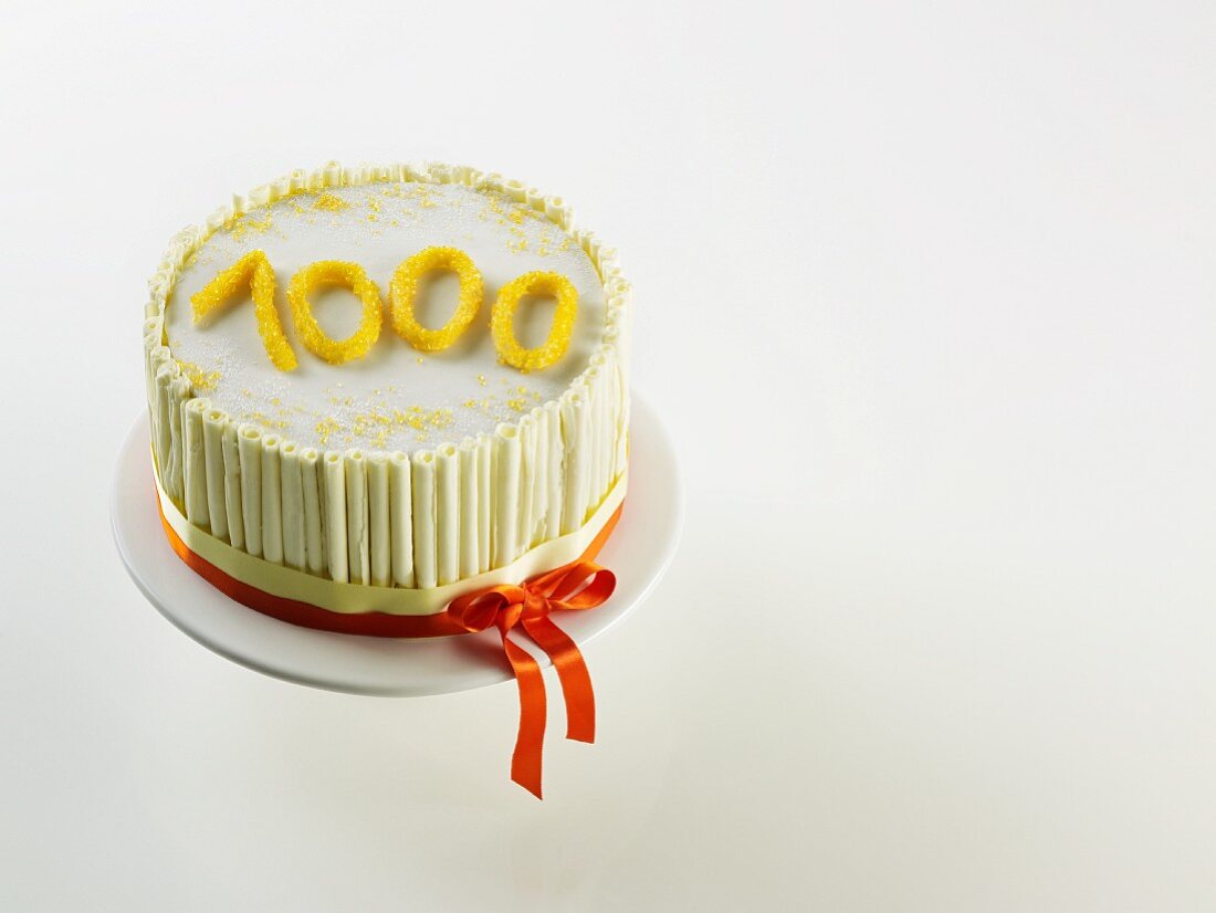 White anniversary cake with the figure '1000'