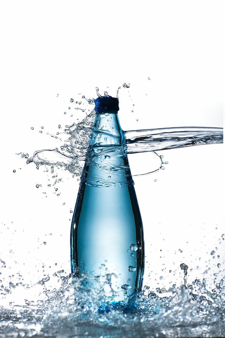 Wasserflasche wird von Wasserstrahl getroffen
