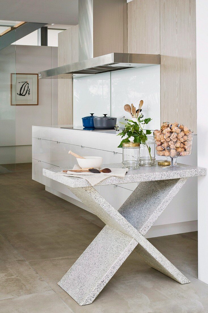 Open-plan designer kitchen with stainless steel extractor hood and island table