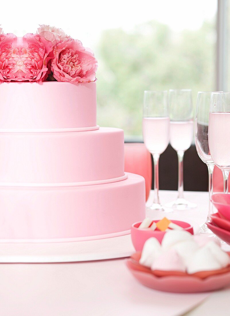 Party buffet with a three-tier cake and sparkling wine