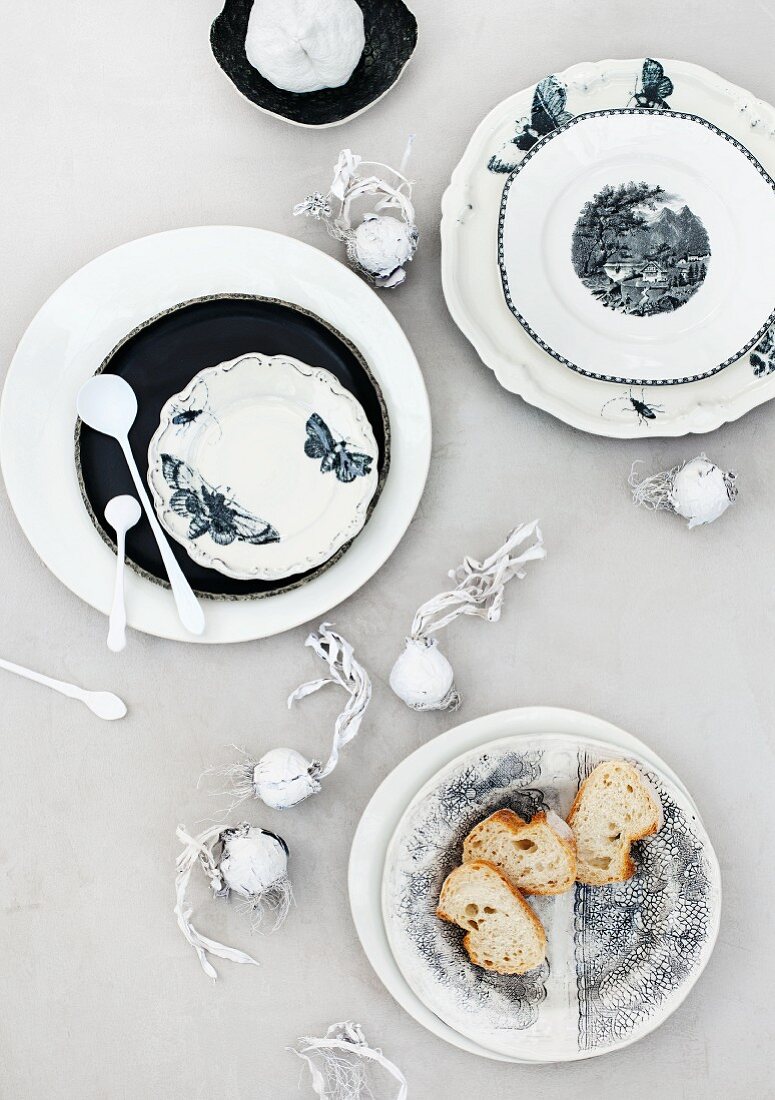 White and blue plates and dried flower bulbs painted white decorating table