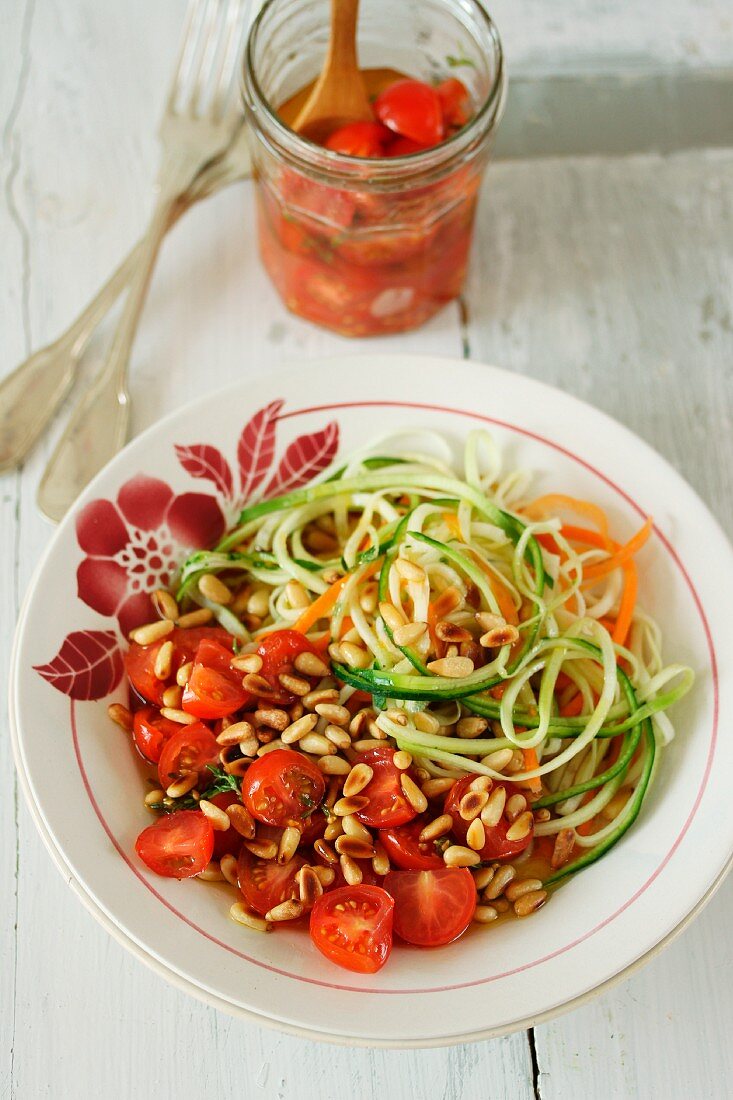 Möhren- und Zucchini-Spaghetti mit marinierten Tomaten und Pinienkernen