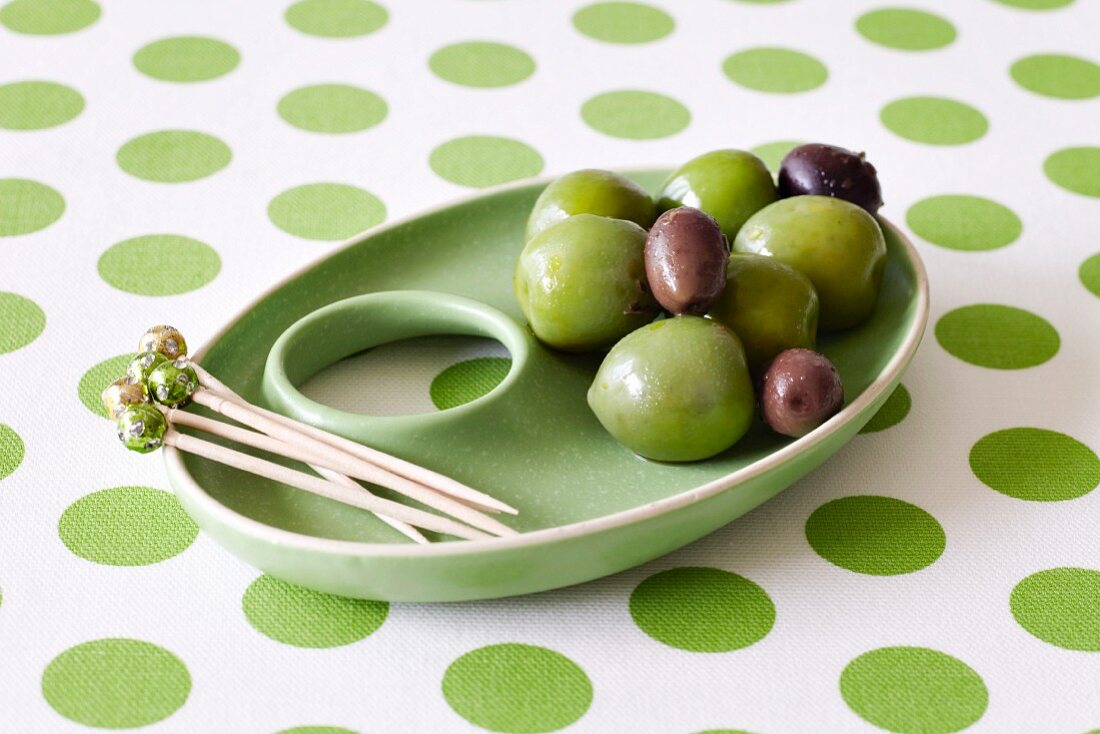 Grünes Schälchen mit Oliven und Zahnstochern