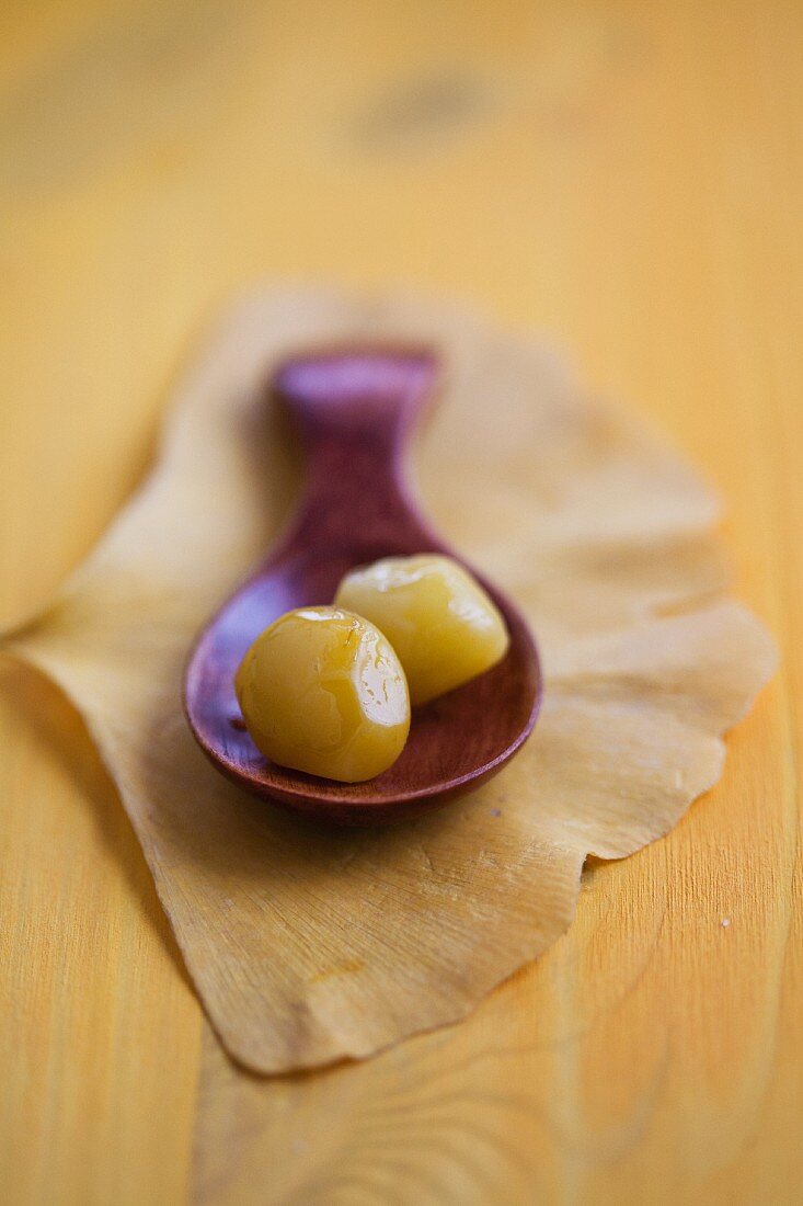 Gingko nuts on a wooden spoon