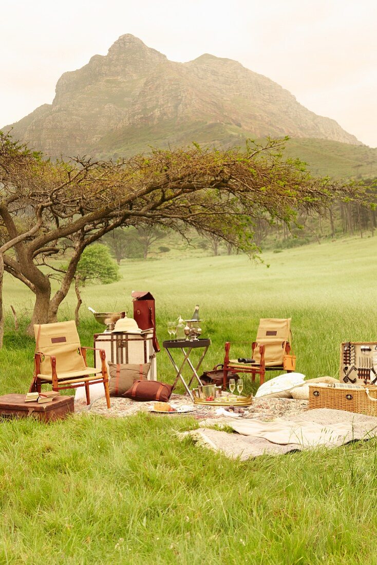 Edle Picknick Ausrüstung und Stühle im Kolonialstil auf der Wiese mit Blick auf Berg