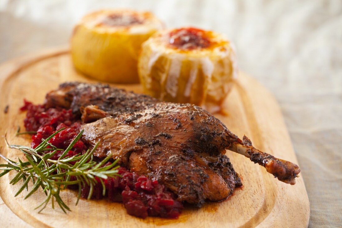 Marinated chicken with cranberry compote; in the background, stuffed butternut squash