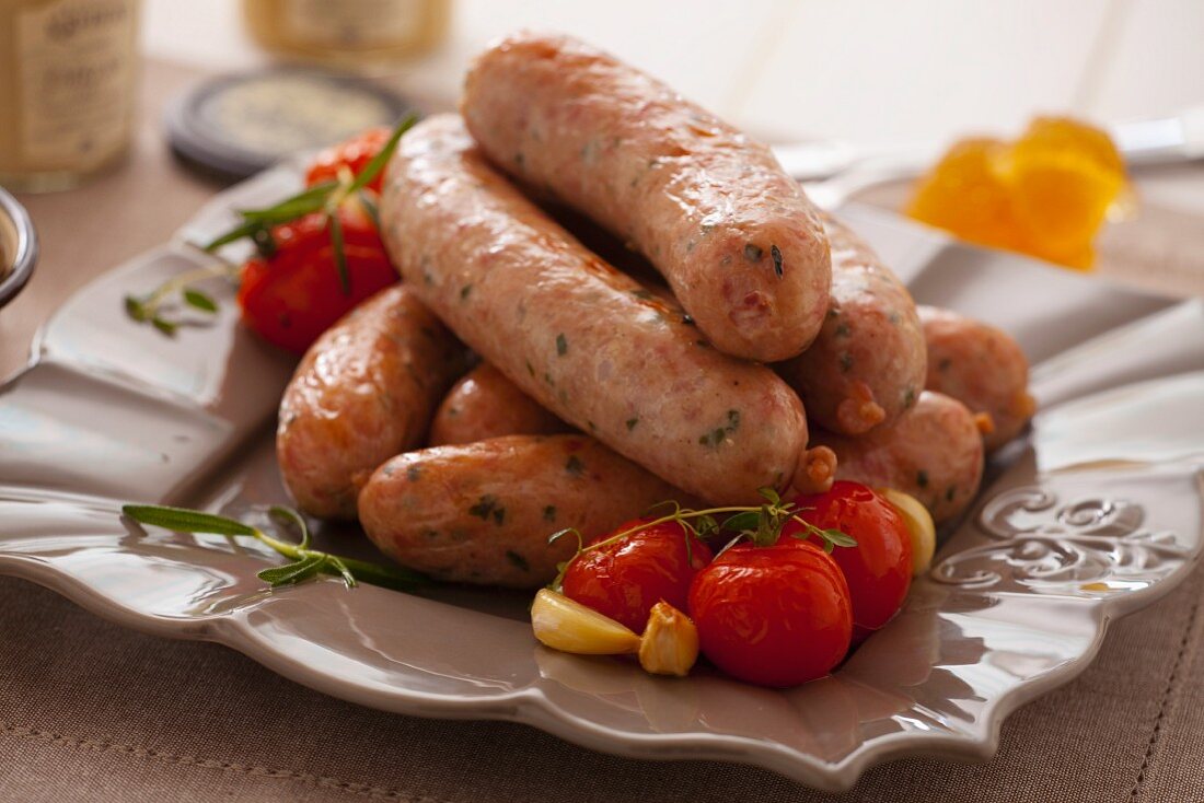Oven-baked sausages with cherry tomatoes, garlic and thyme
