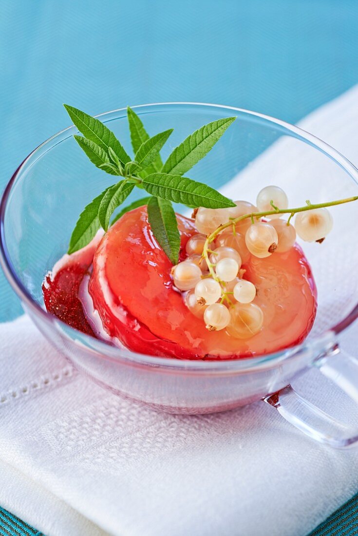 Poached peach slices in a glass teacup