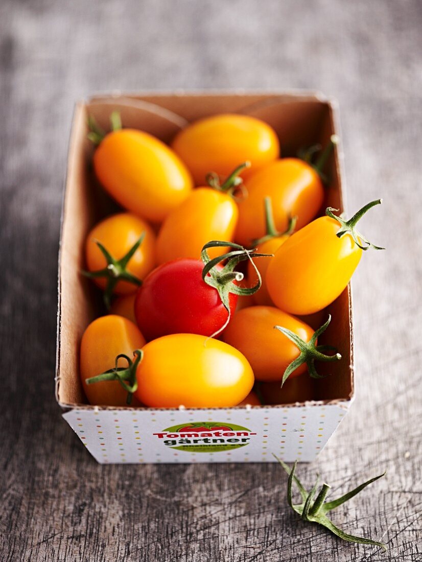 Small yellow tomatoes in a cardboard box