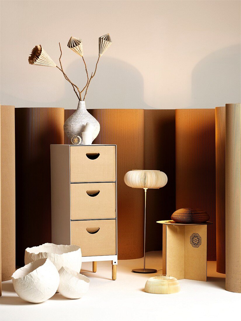 Chest of drawers, stool, standard lamp and vases - designer objects made from wood and paper in warm natural shades