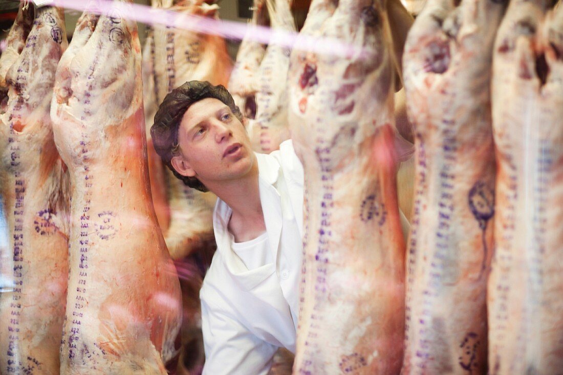 Mann bei der Qualitätskontrolle von Schweinefleisch