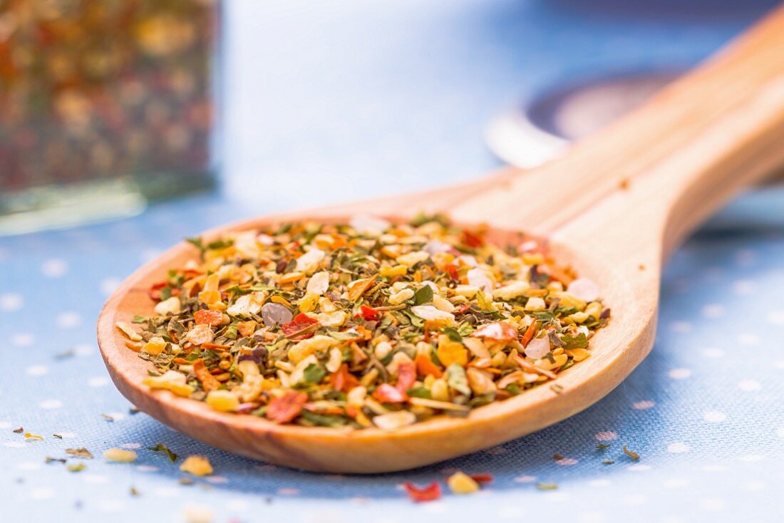 Bruschetta spice mix on a wooden spoon (close-up)